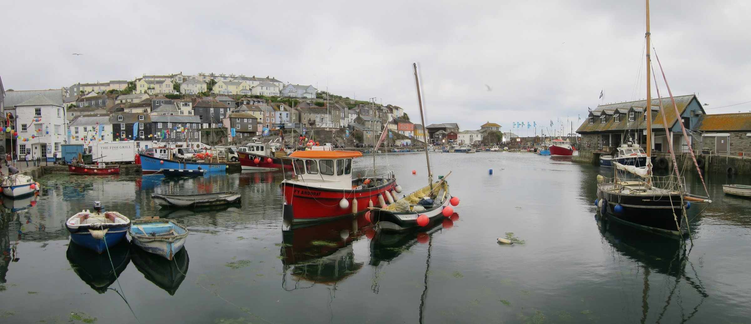 Mevagissey Harbour — colourful fishing boats and hillside cottages on Cornwall's south coast.