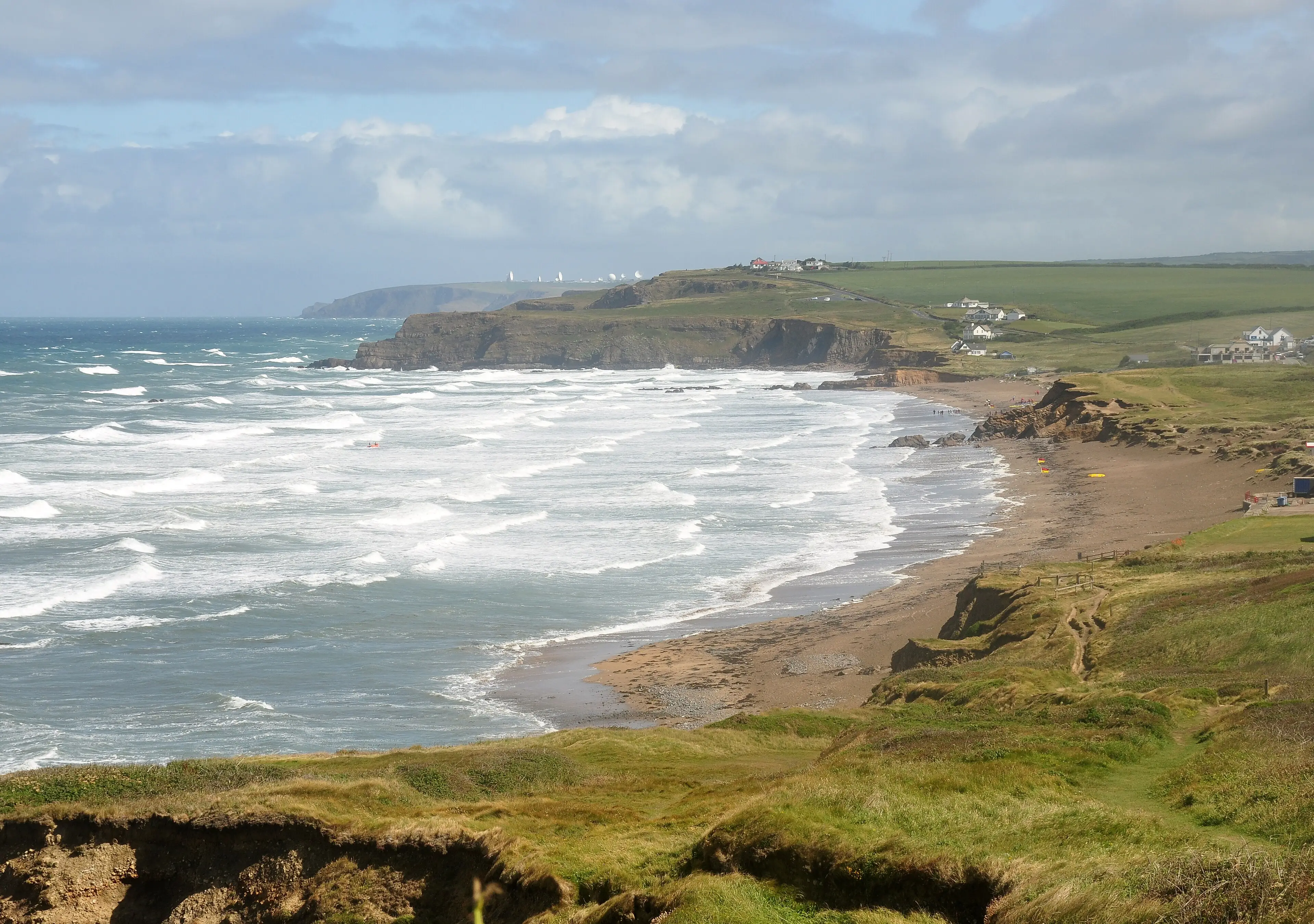 Widemouth Bay near Bude — a long, flat beach with consistent whitewash perfect for beginner surfers.