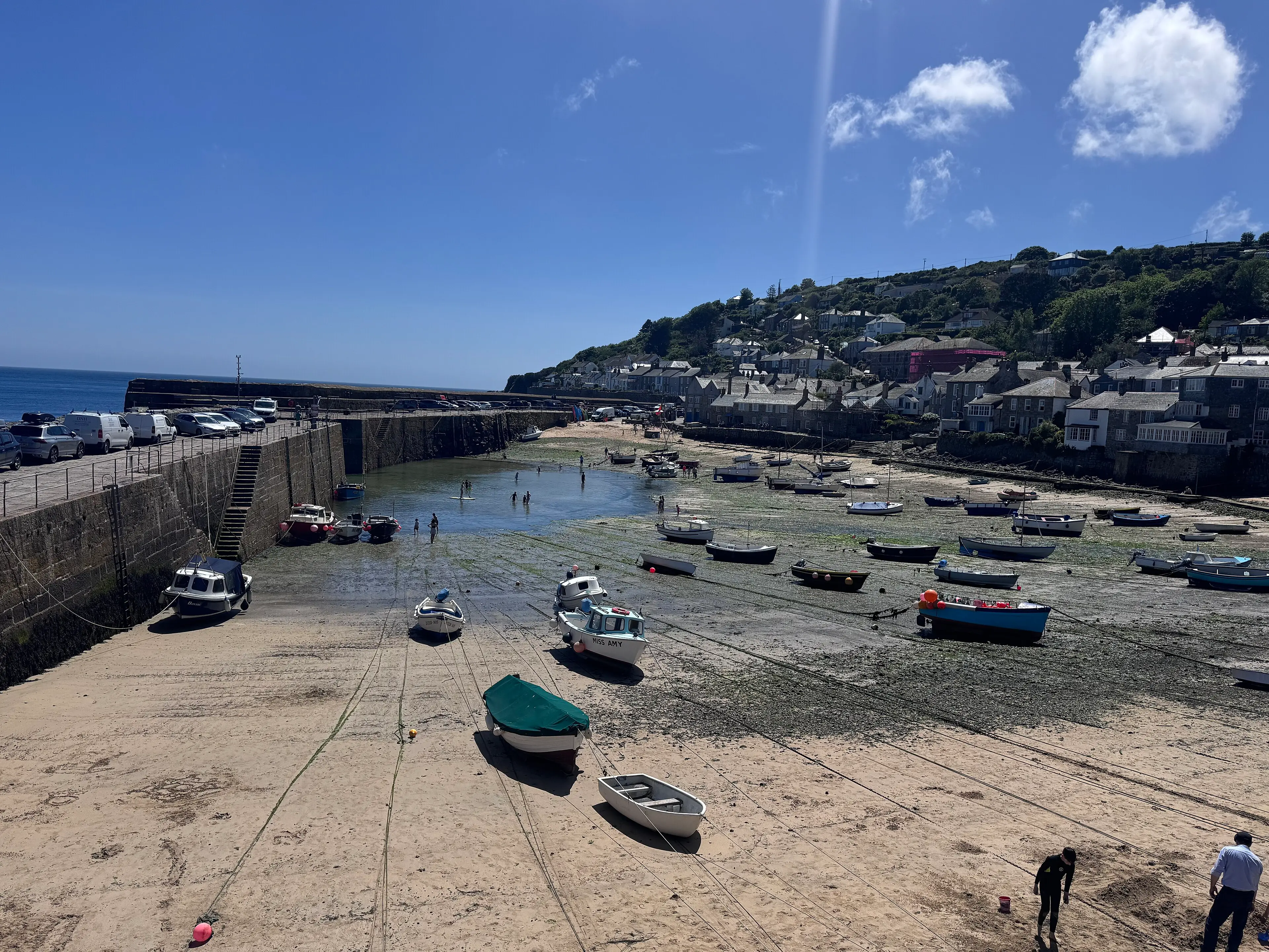 Mousehole harbour at low tide — the iconic Cornish fishing village and its stone harbour walls.